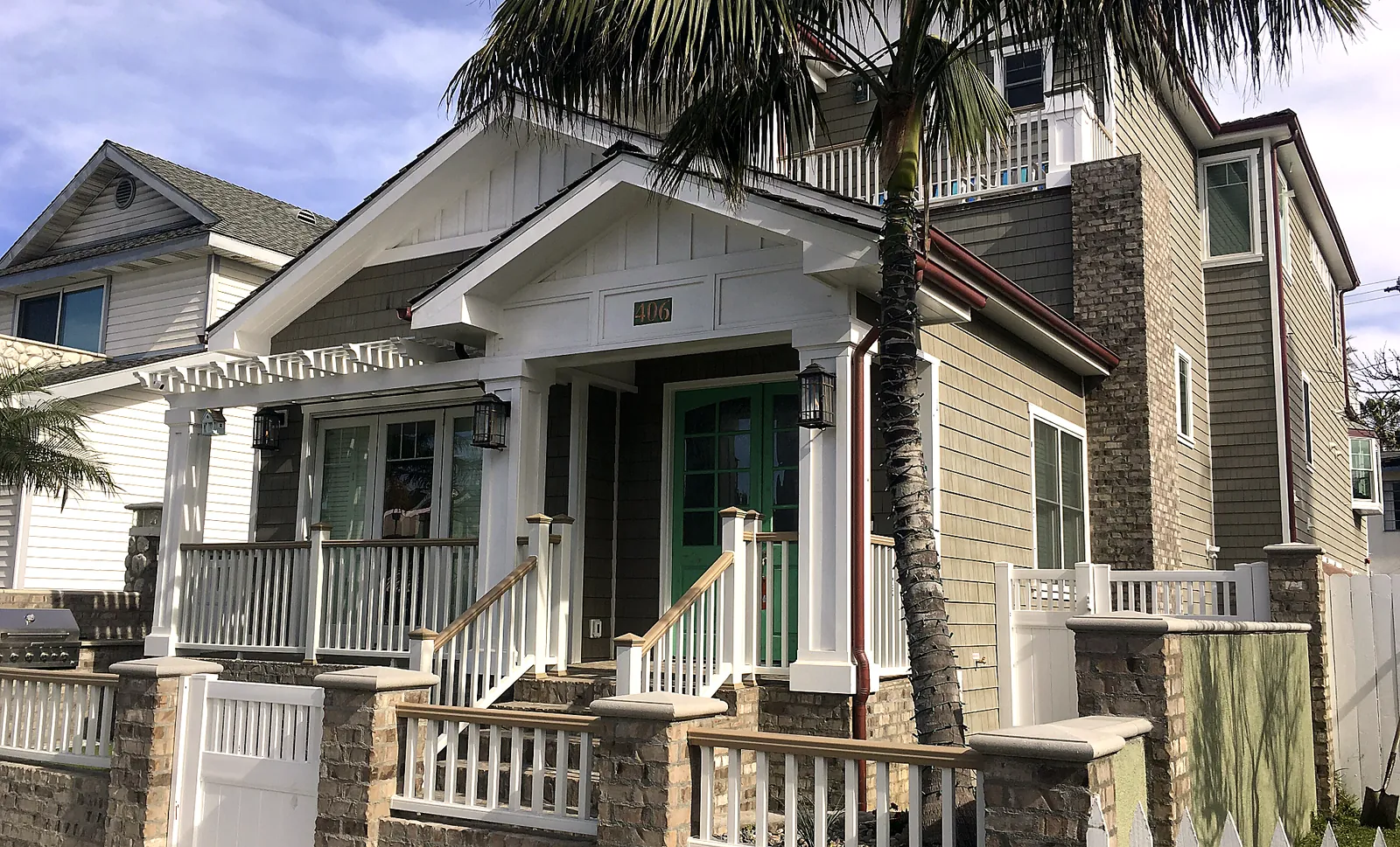 Front of the 7th & Orange Beach House with palm trees
